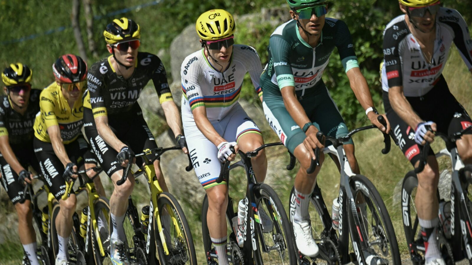 Pogacar (c.) rides for his fifth overall victory